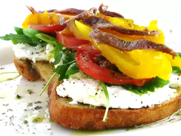 Receita Bruschetta de requeijão, rúcula, tomate, pimento e anchovas