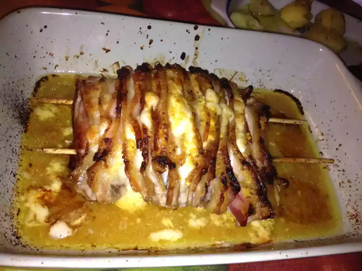 Lombo de porco fatiado com bacon e queijo no forno.