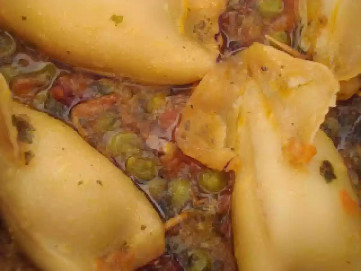 Lulas recheadas com bacon e linguiça em molho de tomate com ervilhas
