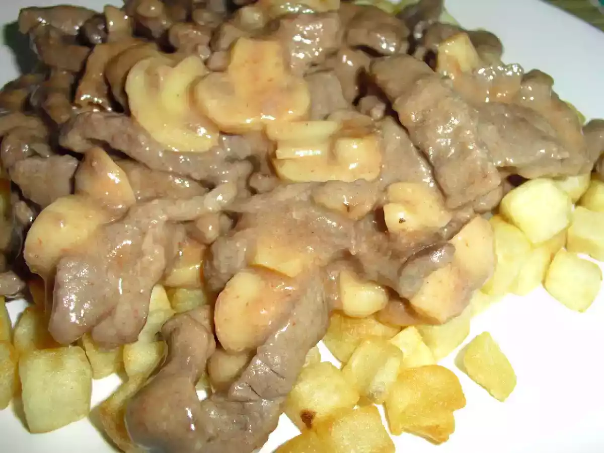Tirinhas de novilho com cogumelos, em cama de batata frita